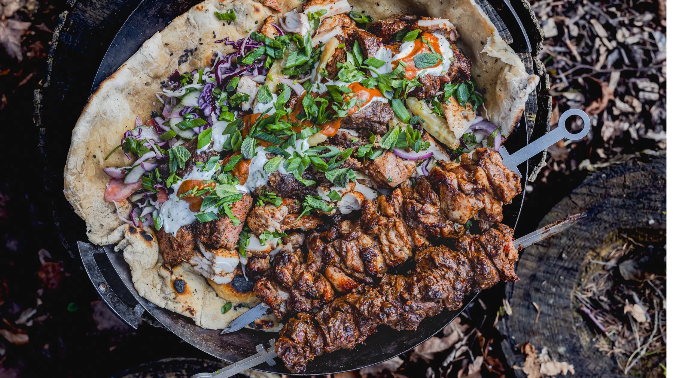 Mixed chicken and lamb kebabs on skewers served with flatbread, fresh herbs, and sauces