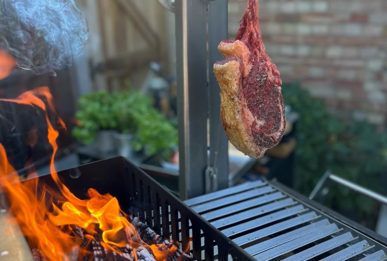 Tomahawk Steak  Hanging over Fire on Argentine Grill 