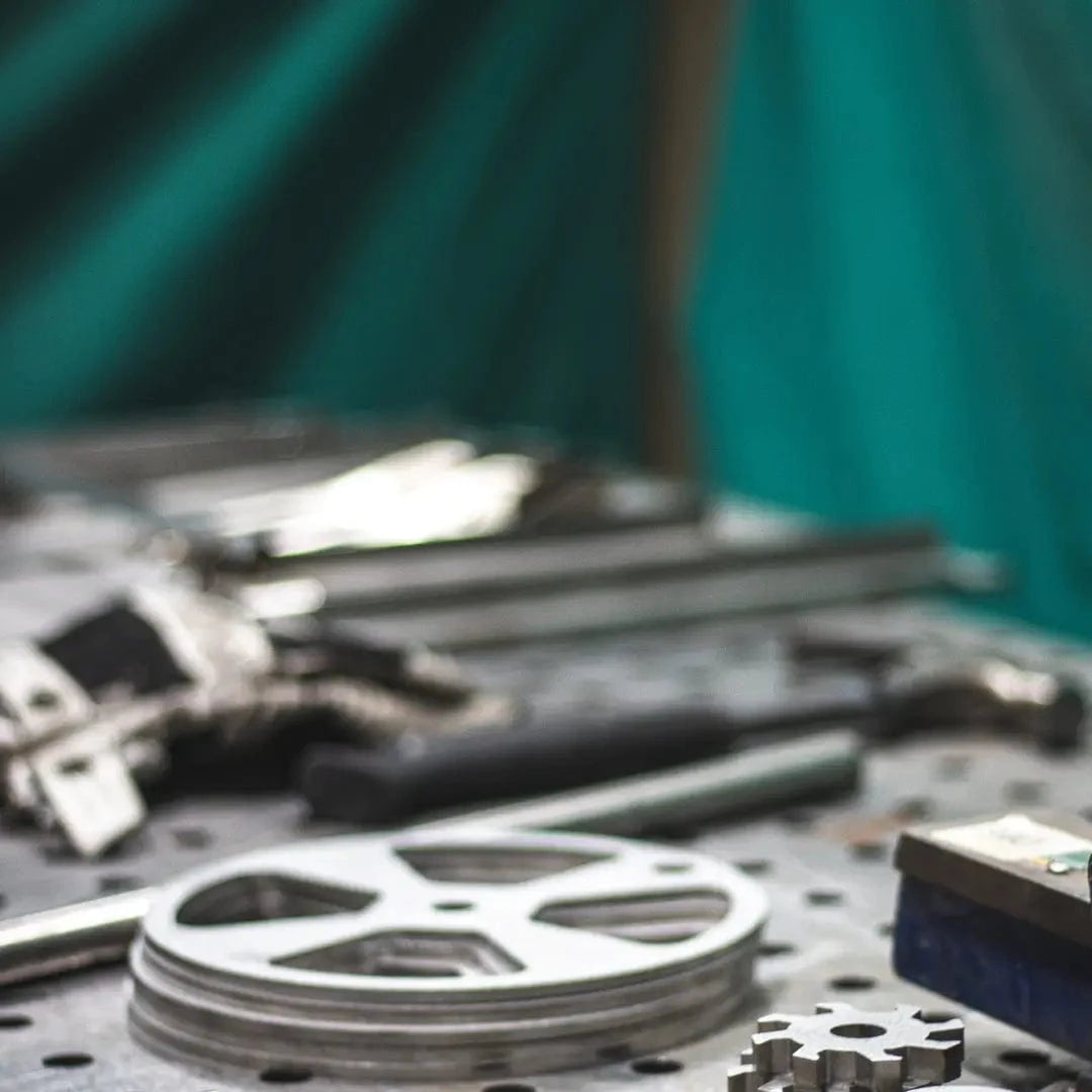 Metal components and tools laid out on a perforated workbench for grill assembly