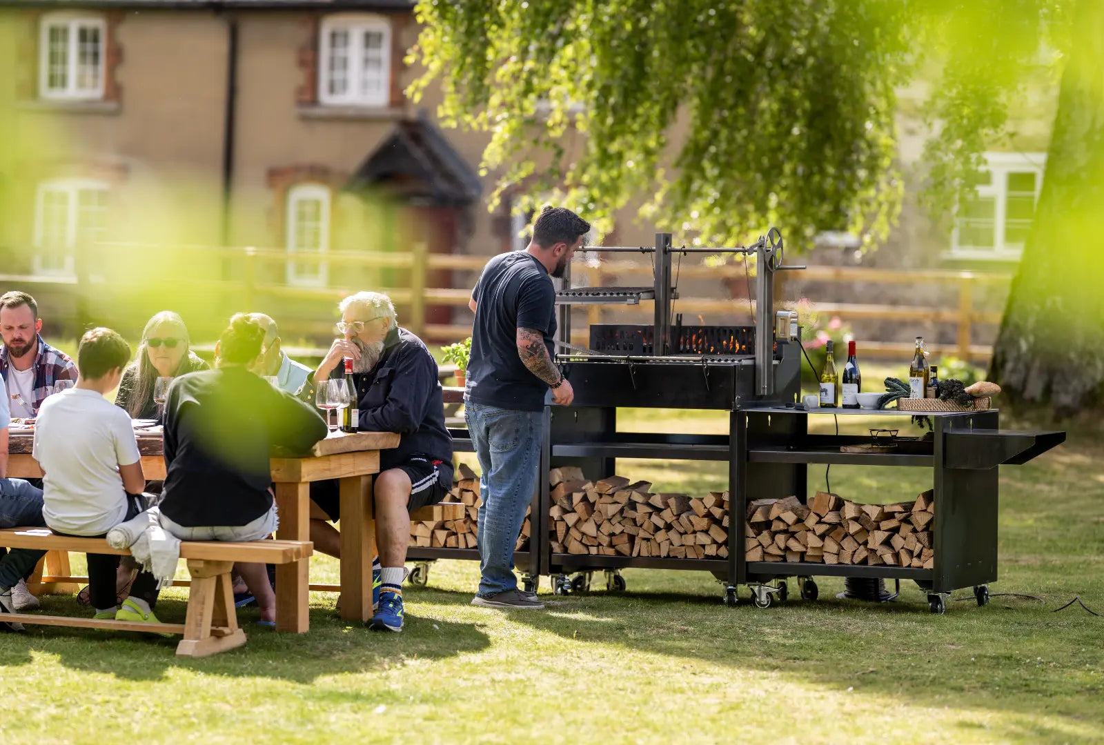 Gunmetal outdoor kitchen bundle with wood storage, grill, and preparation area in garden setting