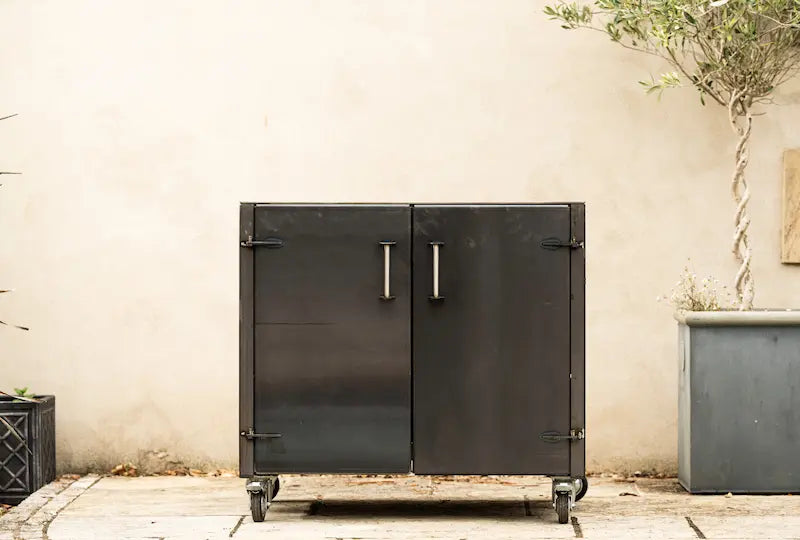 Grande gunmetal worktop unit with two doors and metal handles on caster wheels
