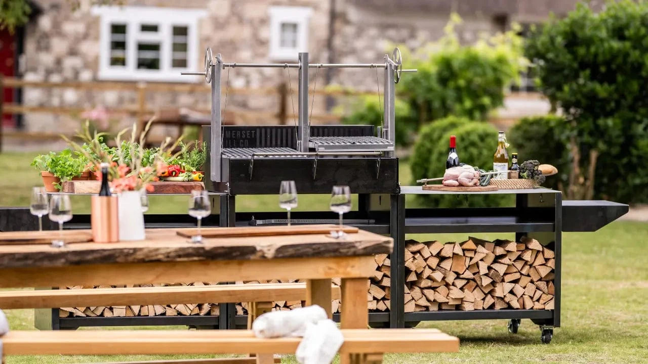 Gunmetal outdoor kitchen bundle with grill, wood storage, and preparation surfaces in garden setting