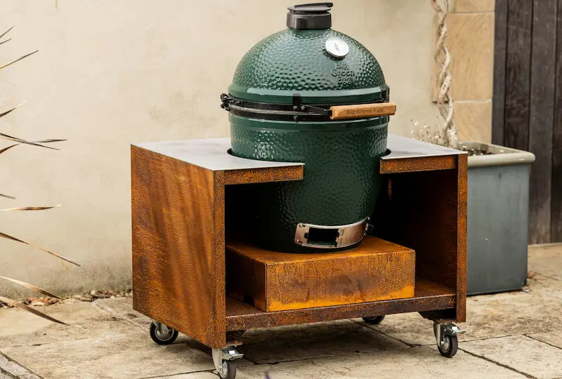 Large green ceramic Big Green Egg barbecue in rust-coloured Cor-Ten steel stand with wheels