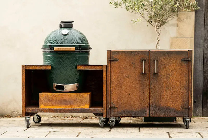 Large green ceramic Big Green Egg barbecue in rusted Cor-Ten steel outdoor unit with storage cabinet